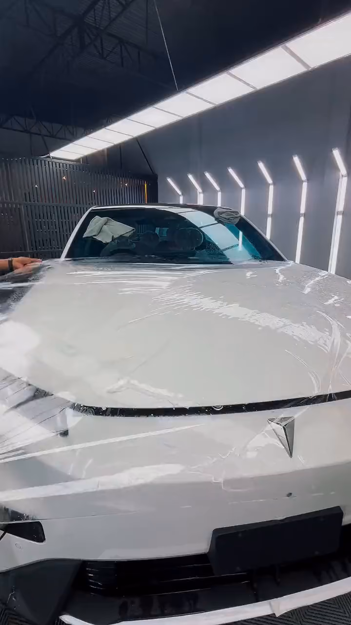 Paint protection film being applied to a white car's bonnet
